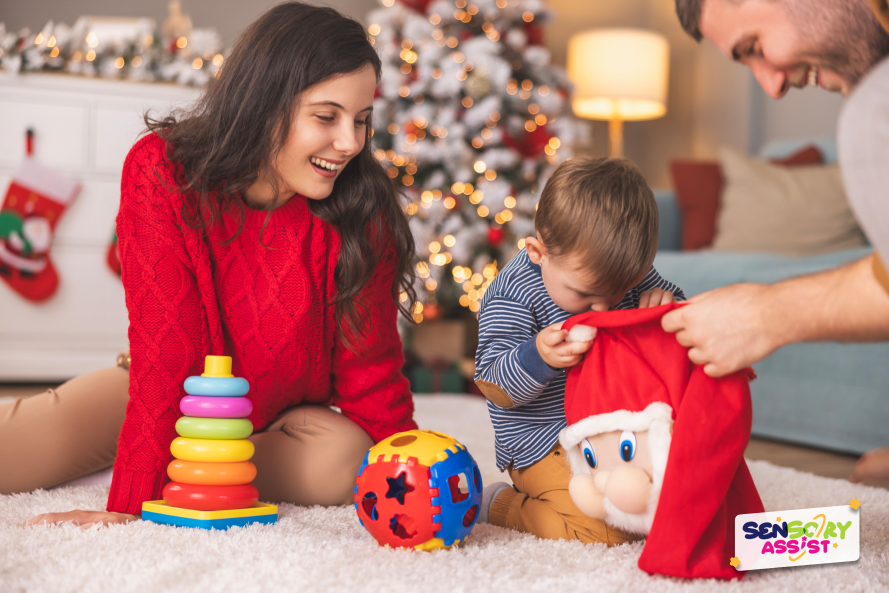 Toddler unpacking Christmas sensory presents with parents at home