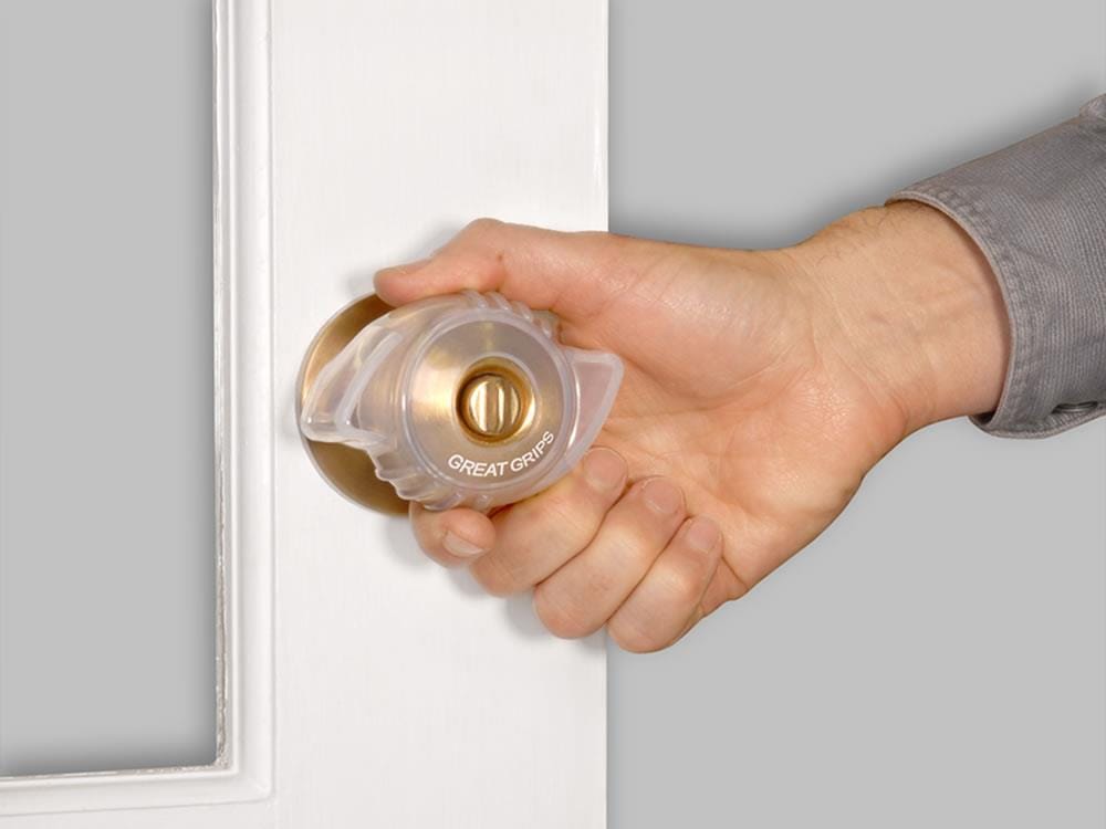 Hand turning a door knob fitted with Great Grips