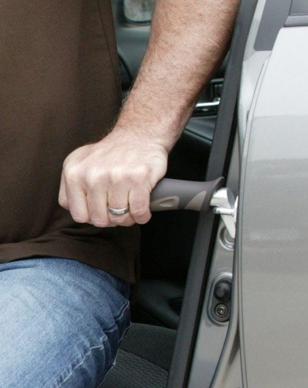 Hand gripping the Metro Car Handle Plus while seated in a car