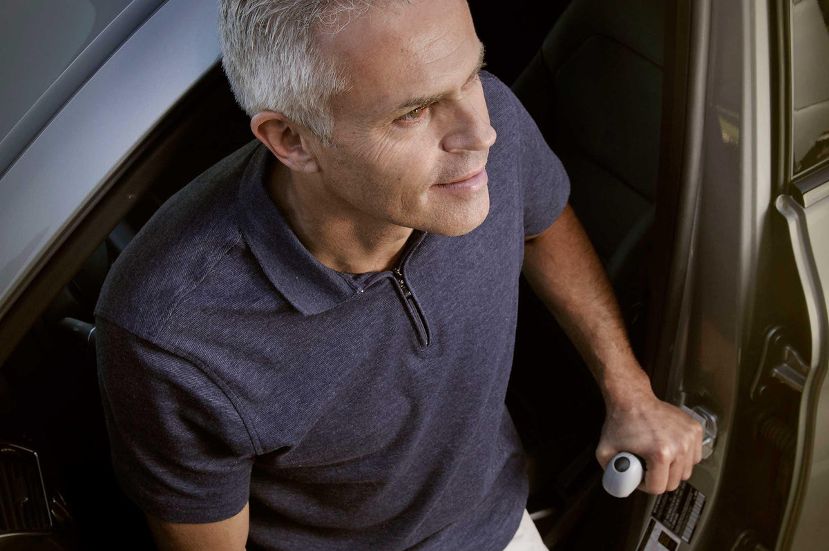 Man gripping the Car Assurance Handle fitted in the door frame