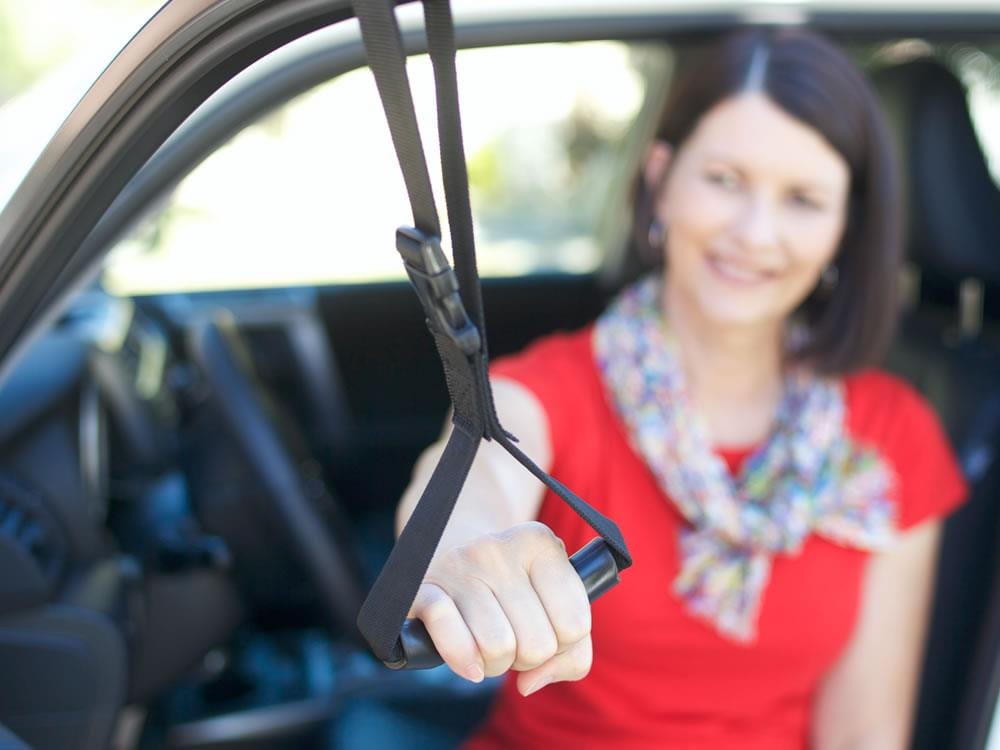 Woman using the Car Caddie handle while seated in the passenger seat