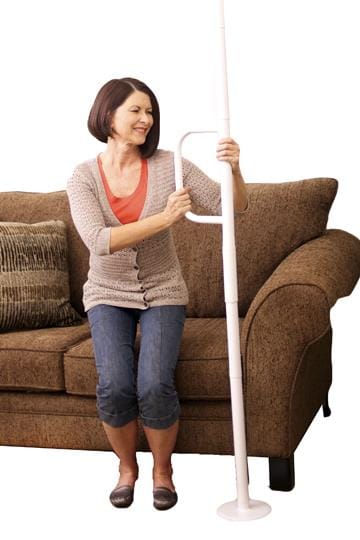 Woman standing beside the Wonder Pole Lite next to a couch