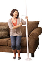 Woman standing beside the Wonder Pole Lite next to a couch