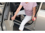 Woman using the Auto Mobility Combo Pack handle to get out of a car