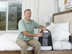 Man seated on a bed using the Bedside Econorail