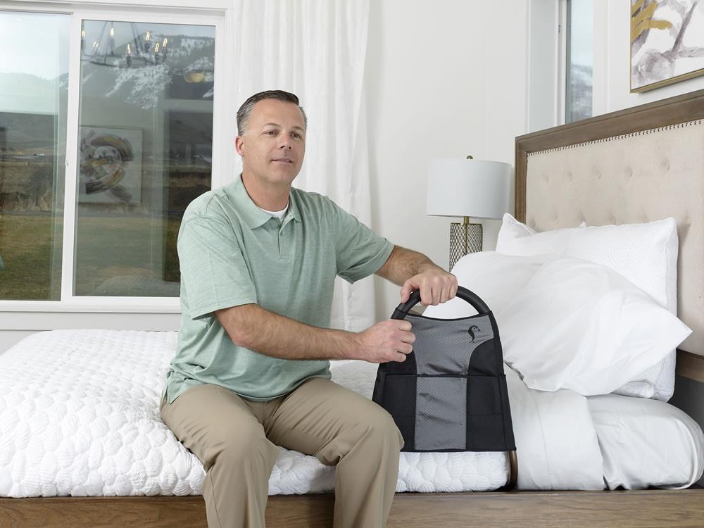 Man seated on a bed using the Bedside Econorail