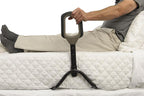 Man sitting on the bed using the Confidence Bed Handle