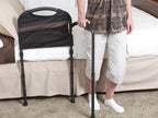 Man standing beside the bed holding the Mobility Bed Rail