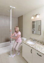 Woman holding the Wonder Pole Slim in a bathroom