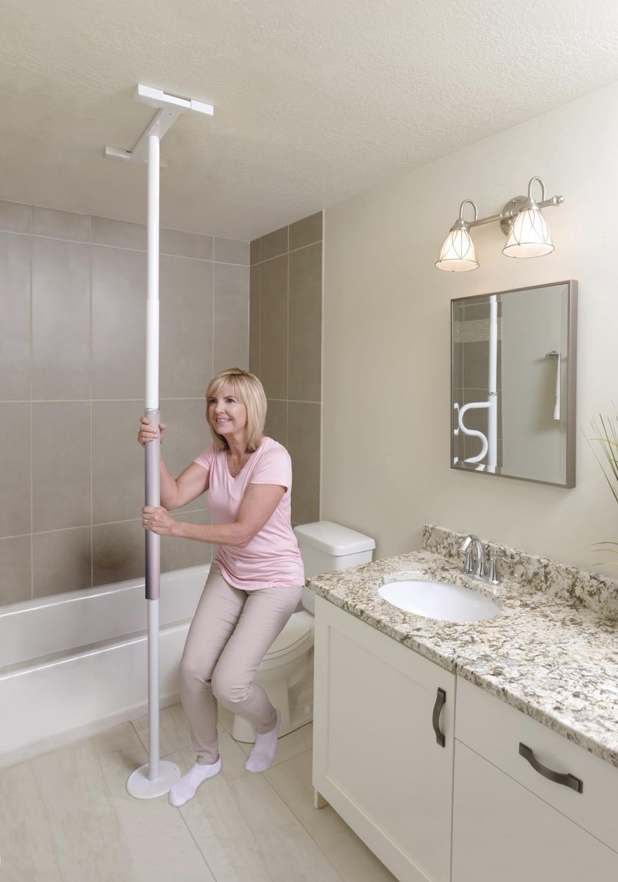 Woman holding the Wonder Pole Slim in a bathroom