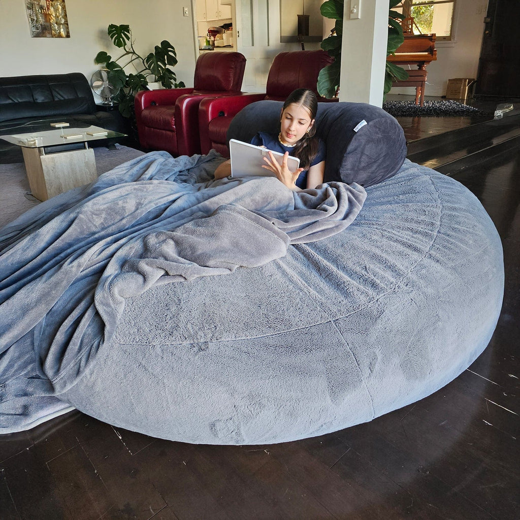 Child reading with a blanket on a Steel Grey Sensory Pod foam beanbag