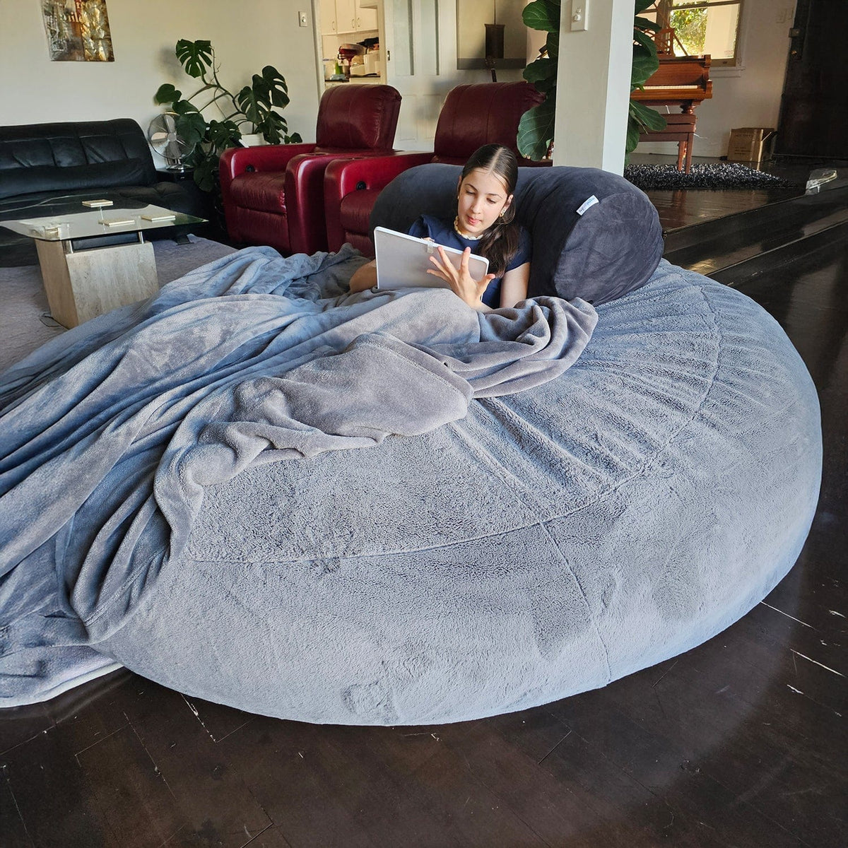 Child reading with a blanket on a Steel Grey Sensory Pod foam beanbag